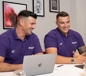 Two men in a board room laughing